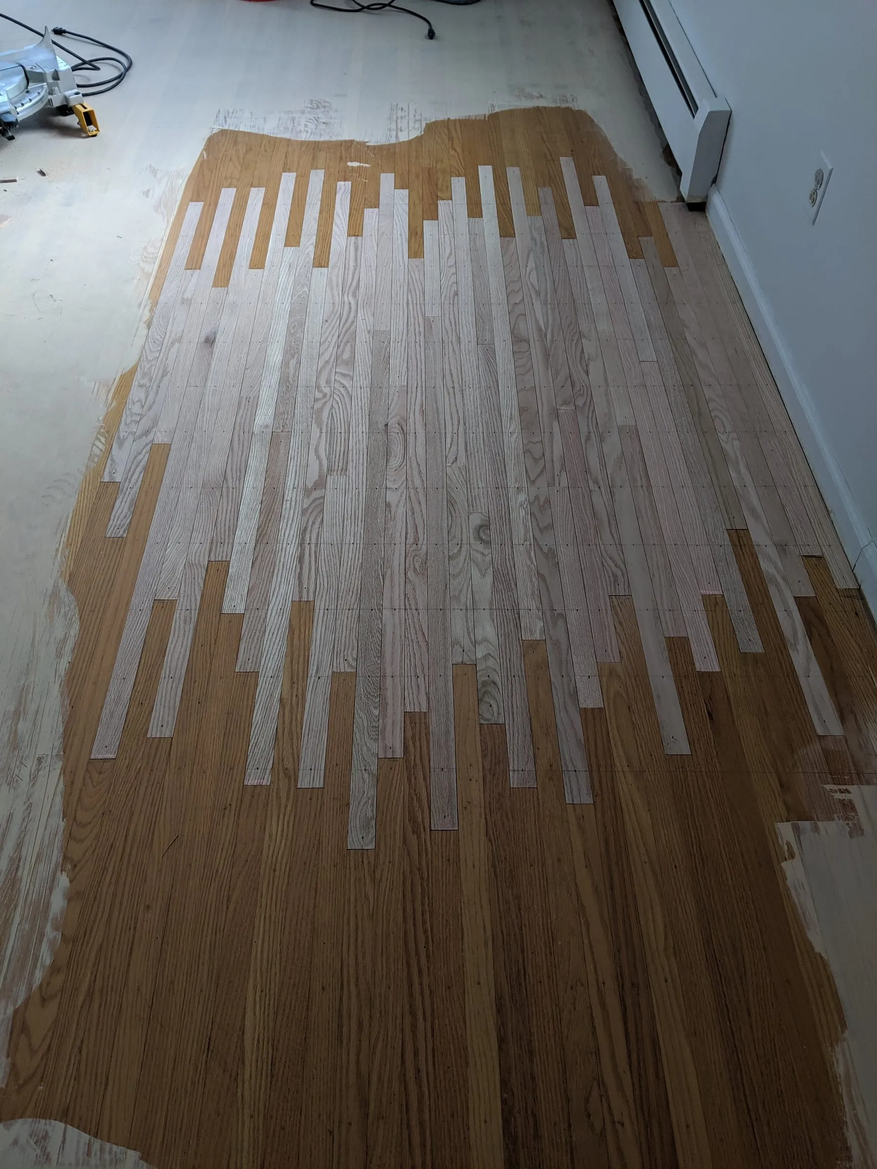 New oak boards woven into an existing floor during a sanding repair