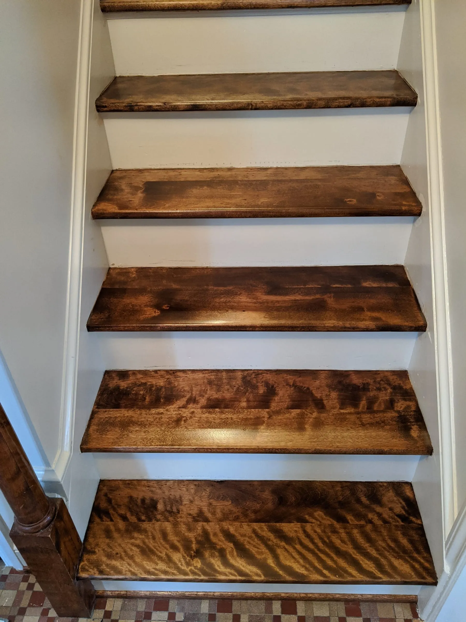 Stair treads with rich figured grain and a dark stain, viewed from above