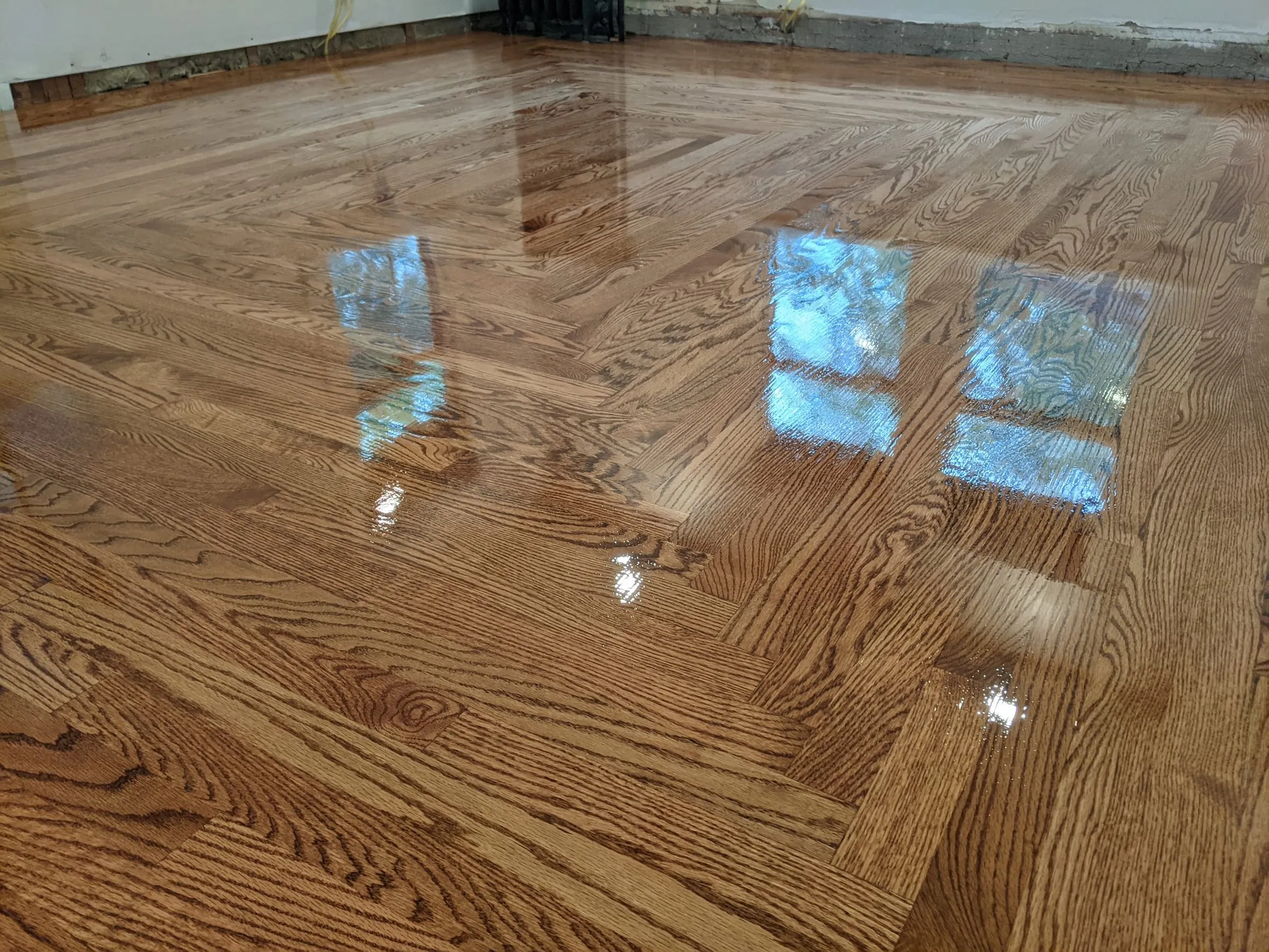 Glossy refinished oak floor with a herringbone border
